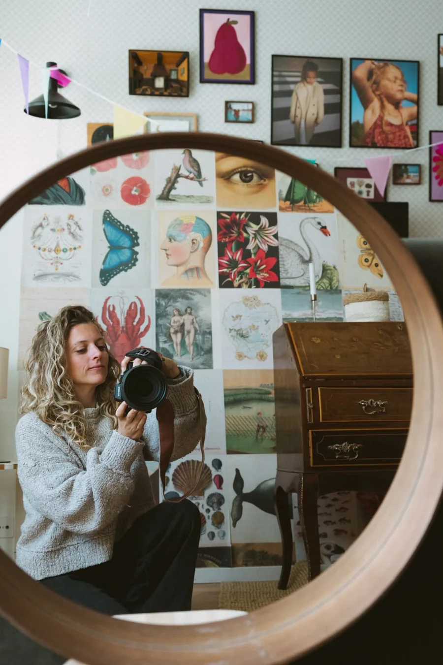 Avji fotografeert zichzelf in een ronde spiegel, thuis in Maasland, met haar camera in haar handen