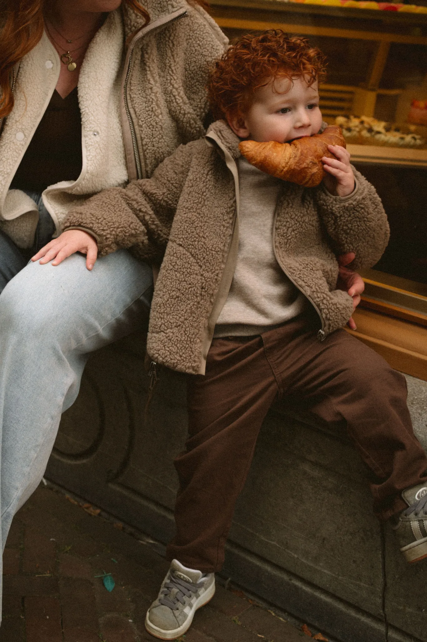 Een kind neemt een hap van een croissant