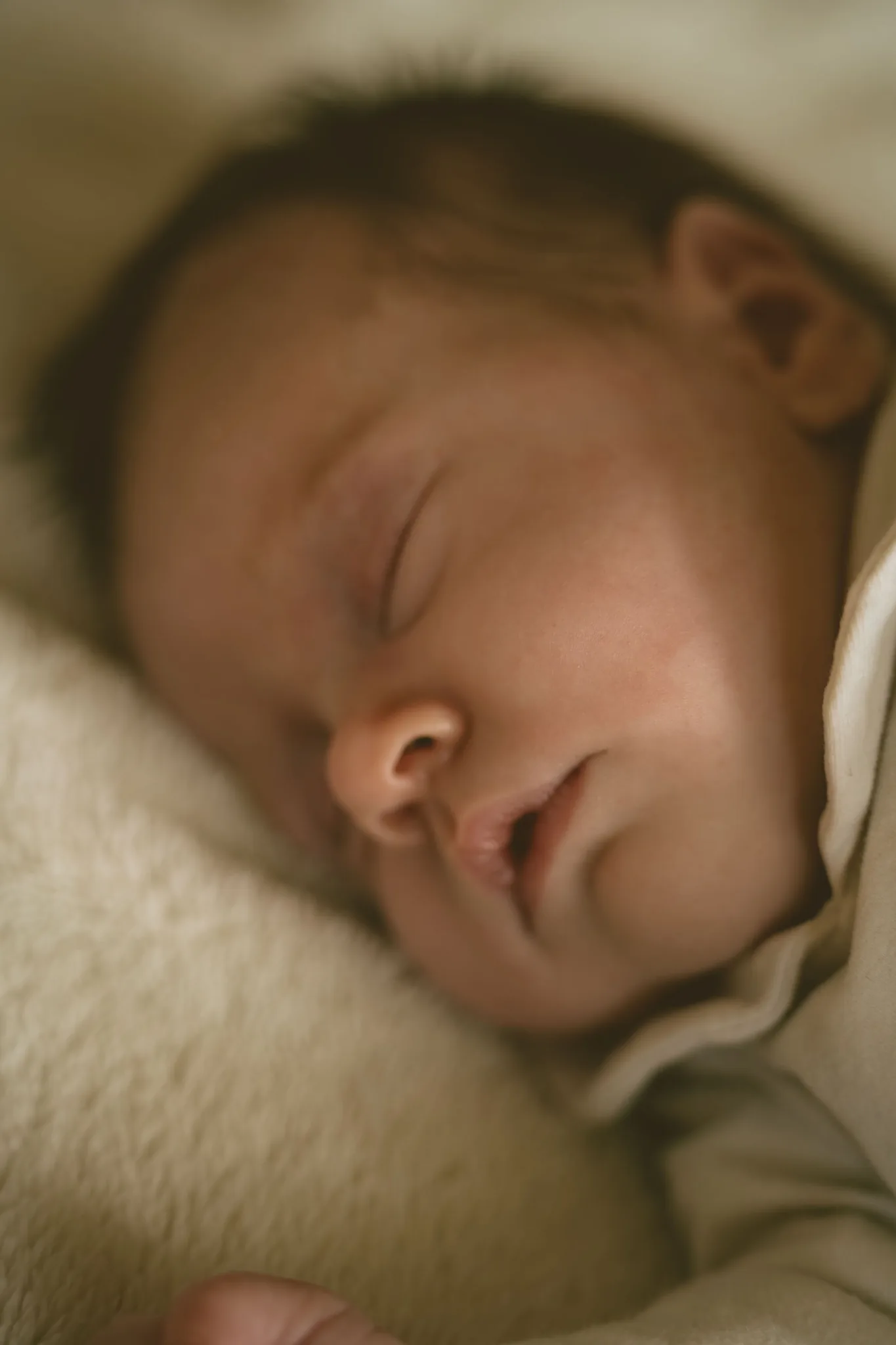 Een pasgeboren baby slaapt, gewikkeld in een lichte doek